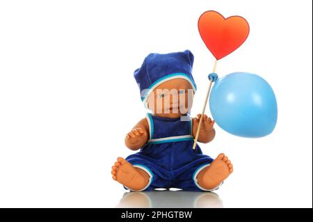 Süße kleine Puppe in blauem Overall und Hut mit Ballons auf weißem Hintergrund. Stockfoto