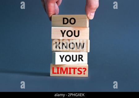 Kennen Sie das Limitsymbol? Konzeptbegriffe kennst du deine Grenzen bei Holzblöcken? Wunderschöner grauer Tischhintergrund. Geschäftsmannshand. Geschäfte Stockfoto