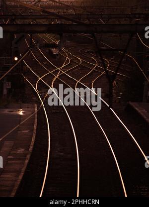 Bahngleise reflektieren den warmen Glanz des Sonnenuntergangs. Der Bahnhof Ashburys befindet sich in Openshaw, der Manchester-Glossop-Linie Stockfoto