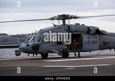 YOKOSUKA, Japan (27. März 2023) – Matrosen, die der Sprengstoffeinheit EODMU 5 zugeordnet sind Japan führen Abseil- und Schnellimpulungen von einem MH-60s Seahawk durch, der an den Goldenen Falken der Kampfgeschwader des Hubschraubers (HSC) 12, an Bord des Befehlshabers, Flottenaktivitäten Yokosuka (CFAY) angeschlossen ist. Seit mehr als 75 Jahren stellt CFAY Basiseinrichtungen und -Dienste zur Unterstützung der vorstationierten Marinekräfte, Mietbefehle und Tausenden von Militär- und Zivilpersonal und deren Familien der US-7.-Flotte zur Verfügung, wartet und betreibt diese. (USA Marinefoto von Taylor Ardito) Stockfoto