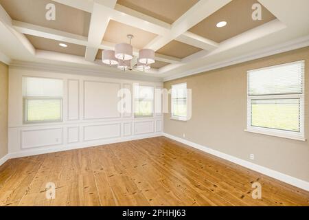 Wunderschönes, maßgeschneidertes Hauptschlafzimmer in Tan mit kompletter Wandvertäfelung, frischer Farbe, Kronen- und Grundformen, Hartholzböden und Kassettendecke Stockfoto