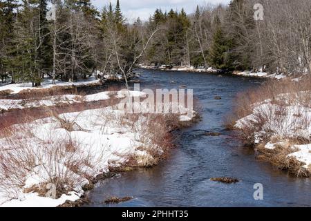 Blick auf den Sacandaga River in den Adirondack Mountains im Spätwinter mit Schnee auf dem Boden Stockfoto