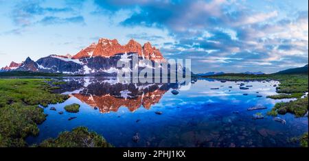 Panoramafoto: Sonnenaufgang beleuchtet die steilen Wände des Rampart-Gebirges über dem Amethyst-See. Tonquin Valley, Kanadische Rocky Mountains, Alberta, Kanada Stockfoto