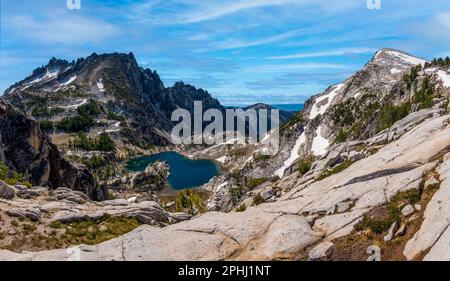 Ein Wasserfall stürzt in Richtung Crystal Lake unter dem McLellan Peak, dem Enchantments Lakes Basin, Cascade Mountain, Washington. Stockfoto