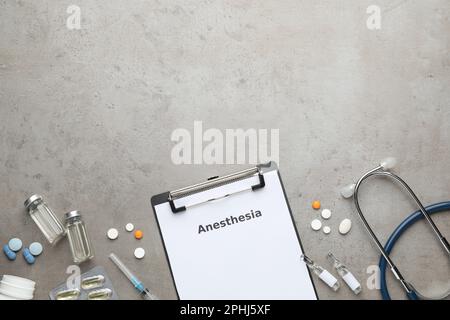 Flache Darstellung des Klemmbretts mit dem Wort Anästhesie und Medikamente auf grauem Tisch, Platz für Text Stockfoto