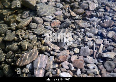 Steine und Kiesel auf dem Grund des Flusses Stockfoto