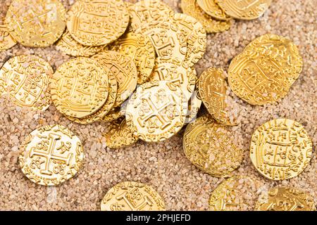 Eine vergrabene Piratenschatzmünze im Sand an einem Strand Stockfoto