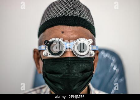 Bogor, Indonesien. 27. März 2023. Ein indonesischer Einwohner lässt seine Augen am 27. März 2023 bei Untersuchungen in der Ainun Cahaya Medika Augenklinik in Bogor Regency, Indonesien, untersuchen. Das Programm zielt darauf ab, benachteiligten Gemeinschaften zu helfen, Augengesundheitsdienste zu erhalten, um die Blindheit aufgrund von Katarakt zu reduzieren. (Foto: Andi M Ridwan/INA Photo Agency/Sipa USA) Guthaben: SIPA USA/Alamy Live News Stockfoto