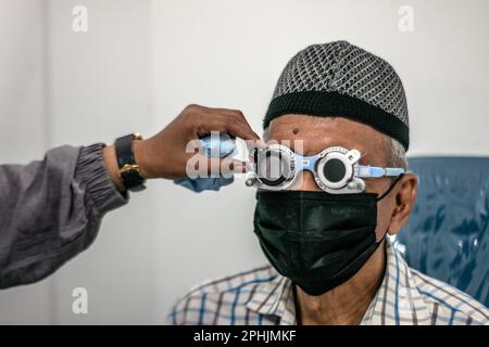 Bogor, Indonesien. 27. März 2023. Ein indonesischer Einwohner lässt seine Augen am 27. März 2023 bei Untersuchungen in der Ainun Cahaya Medika Augenklinik in Bogor Regency, Indonesien, untersuchen. Das Programm zielt darauf ab, benachteiligten Gemeinschaften zu helfen, Augengesundheitsdienste zu erhalten, um die Blindheit aufgrund von Katarakt zu reduzieren. (Foto: Andi M Ridwan/INA Photo Agency/Sipa USA) Guthaben: SIPA USA/Alamy Live News Stockfoto