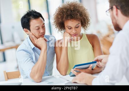 Dies ist Ihre neue Monatsrate. Ein junges Paar trifft sich mit seinem Berater in seinem Büro. Stockfoto