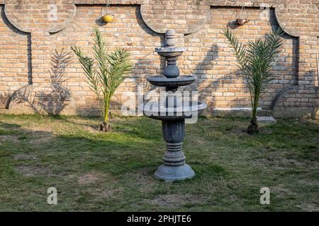 Springbrunnen aus schwarzem Marmor im Garten Stockfoto