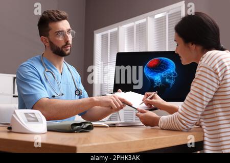 Junge Frau, die das Formular in der neurologischen Praxis ausfüllt Stockfoto