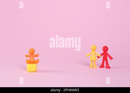 MYKOLAIV, UKRAINE - 04. JANUAR 2022: Bunte menschliche Figuren auf rosa Hintergrund, Platz für Text. Leihmutterschaftskonzept Stockfoto