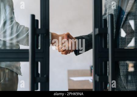Nahaufnahme von unbekannten Geschäftspartnern, die sich die Hände schütteln, vereinbaren einen Deal im Büro. Zwei Geschäftsmänner, die nach erfolgreichem Projekt die Hand schütteln. Stockfoto