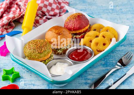 Drei Mini-Burger mit Huhn und Fleisch serviert mit pommes frites. Kindermenü Stockfoto