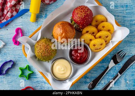 Drei Mini-Burger mit Huhn und Fleisch serviert mit pommes frites. Kindermenü Stockfoto