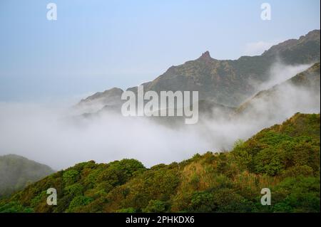 Jiufen's Mountains und sich verflochtene weiße Wolken in der tagsüber herrlichen Landschaft, ruhige Forest Vistas und Misty White Clouds. New Taipeh, Taiwan Stockfoto