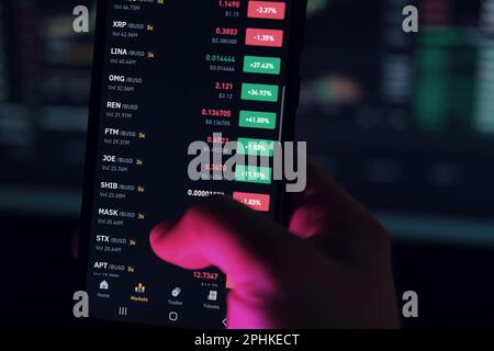 Geschäftsmann, der die Börse mit dem Smartphone überprüft. Mann, der ein Mobiltelefon mit einer Investitionsanwendung verwendet. wertpapieranlagen und Handel cr Stockfoto