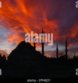 Foto im quadratischen Format im Ramadan- oder islamischen Konzept. Silhouette der Suleymaniye-Moschee und dramatischer Himmel bei Sonnenuntergang. Stockfoto