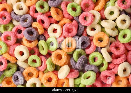 Süße, leckere bunte Maisringe als Hintergrund, Draufsicht Stockfoto