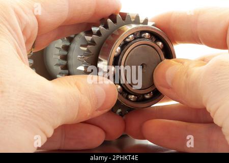 Hände bei der Arbeit mit Getriebeteilen, Hände im Einsatz mit Getriebeteilen Stockfoto