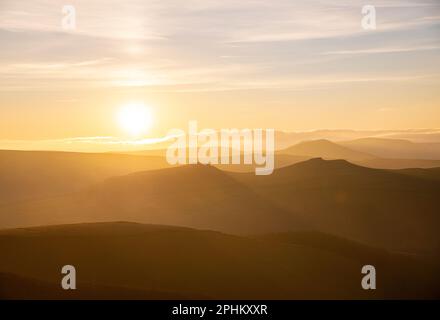 Sonnenuntergang über den Hügeln des Dark Peak District des English Peak District. Blick von Derwent Edge in der Nähe des Ladybower Reservoir in einer trüben Landschaft Stockfoto