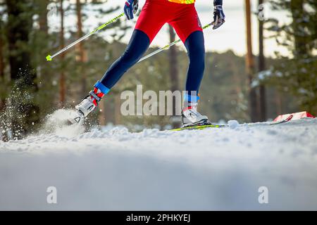 Männlicher Skifahrer, der beim Skilanglauf bergauf läuft, Fischer Rennskier, Rossignol-Skischuhe, wintersport mit olympiade Stockfoto