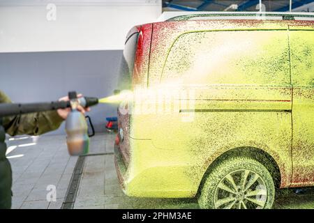 Die Autos in der Garage mit grünem Aktivschaum waschen Stockfoto