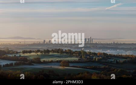 Ferne Türme von Manchester an einem frostigen Wintermorgen mit etwas Nebel in der Luft und Hügeln, Bäumen, Landschaften und Landschaft im Vordergrund Stockfoto