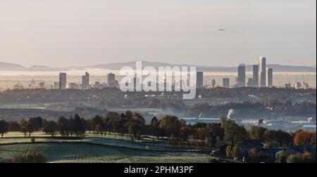 Ferne Türme von Manchester an einem frostigen Wintermorgen mit etwas Nebel in der Luft und Hügeln, Bäumen, Landschaften und Landschaft im Vordergrund Stockfoto