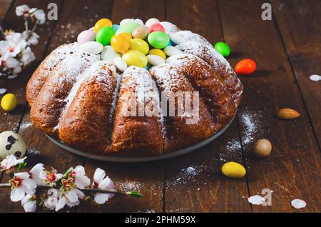 Osterkuchen, traditioneller Kuchen, dekoriert mit Zuckereiern auf Holzhintergrund Stockfoto