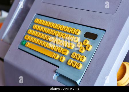 Integrierte Farbtastatur mit gelben mechanischen Tasten für den Computer einer großen industriellen Strickmaschine Stockfoto