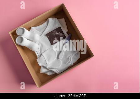 Box mit Babyzeug und Schwangerschaftstest. Stockfoto