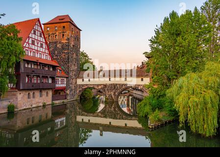 Blick auf den Sonnenuntergang über das Weinstadel-Gebäude, den Wasserturm, die Henkerbrücke und den Henkerturm in Nürnberg. Stockfoto