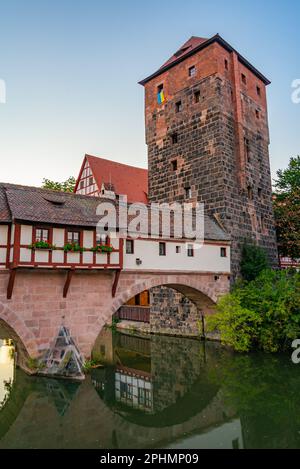 Blick auf den Sonnenuntergang über das Weinstadel-Gebäude, den Wasserturm, die Henkerbrücke und den Henkerturm in Nürnberg. Stockfoto