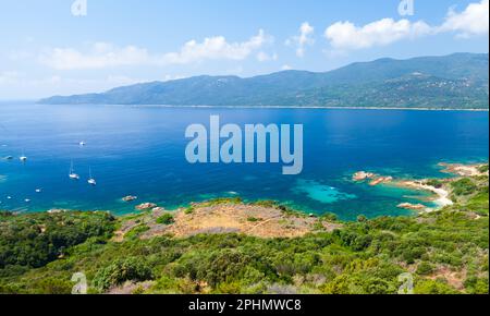 Korsika Insel an einem sonnigen Tag, Kupabia Golf. Sommerlandschaft mit Vergnügungsbooten, die in der Nähe der felsigen Küste vor Anker liegen Stockfoto