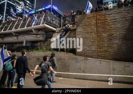 25. März 2023, Tel Aviv, Israel: Demonstranten klettern eine Mauer hinunter, während sie während einer Antireformdemonstration in Tel Aviv versuchen, sich der Blockade der Autobahn Ayalon anzuschließen. Mehr als 230.000 Menschen protestieren in Tel Aviv gegen die rechtsextreme Regierung von Netanyahuâ€™und ihre umstrittene Rechtsreform. (Credit Image: © Matan Golan/SOPA Images via ZUMA Press Wire) NUR ZUR REDAKTIONELLEN VERWENDUNG! Nicht für den kommerziellen GEBRAUCH! Stockfoto