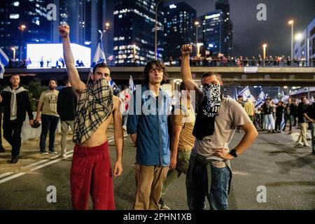 25. März 2023, Tel Aviv, Israel: Maskierte Anti-Reform-Demonstranten erheben während einer Anti-Reform-Demonstration in Tel Aviv ihre Fäuste auf der blockierten Ayalon-Autobahn. Mehr als 230.000 Menschen protestieren in Tel Aviv gegen die rechtsextreme Regierung von Netanyahuâ€™und ihre umstrittene Rechtsreform. (Credit Image: © Matan Golan/SOPA Images via ZUMA Press Wire) NUR ZUR REDAKTIONELLEN VERWENDUNG! Nicht für den kommerziellen GEBRAUCH! Stockfoto