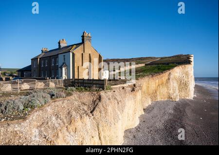 Die Küstenwache Cottages in Birling Gap am Rand einer Klippe, die der Küstenerosion ausgesetzt ist, werden ins Meer gespült. Stockfoto