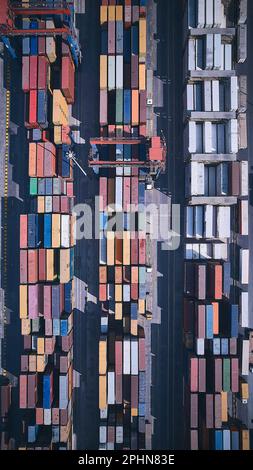 Gestapelte Frachtcontainer von oben nach unten aus der Vogelperspektive. Container am Logistikterminal. Frachtcontainer im Außenlager Stockfoto
