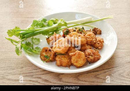 Knusprig gefülltes Tofu-Mehl Dressing Knoblauch und Pfeffer mit Frühlingszwiebeln und Petersilie auf dem Teller Stockfoto