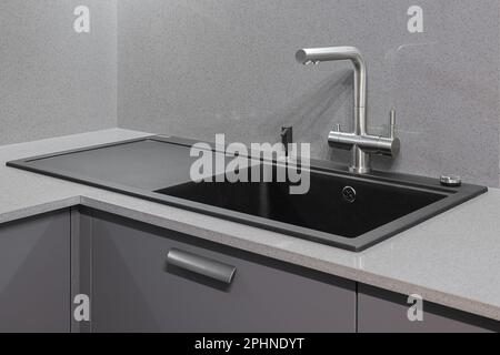 Wasserhahn und Granitwaschbecken in der modernen Küche Stockfoto