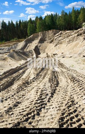 Reifenspuren von Hydraulikbaggern auf Sandsteinbruch. Stockfoto