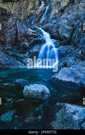 Schöner Wasserfall mit verschwommenem Wassereffekt. Foto im Tal der fünf Teiche in der polnischen Tatra. Foto mit langer Belichtung. Stockfoto