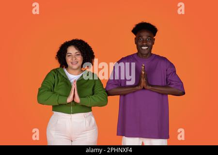 Ein gemischtes Paar hat die Hände vor sich gefaltet Stockfoto