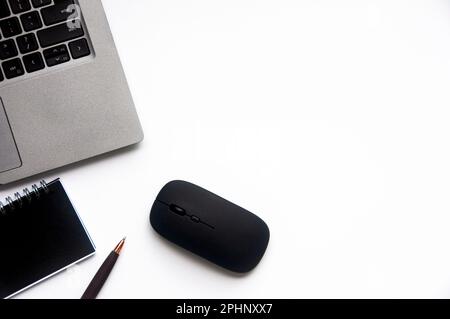 Draufsicht von Laptop, Notizblock und Maus auf weißem Deckelhintergrund mit anpassbarem Platz für Text. Speicherplatz kopieren. Stockfoto