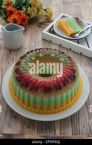 Farbenfroher Pudding gefüllt mit Kiwis und Erdbeerstücken auf einem weißen Teller Stockfoto
