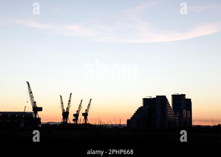 Sonnenuntergang über den Kranen in den Apartments BAE Systems Govan Shipyard und Glasgow Harbour im Jahr 2012, Glasgow, Schottland, Großbritannien. Die Kräne wurden abgerissen Stockfoto