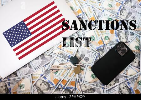 Konzept der Sanktionsliste. US-Flagge, Dollargeld mit Schlüsseln, Laptop- und Telefonhintergrund. Stockfoto