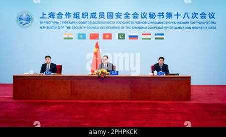 Peking, China. 29. März 2023. Der chinesische Staatsrat und Minister für öffentliche Sicherheit Wang Xiaohong nimmt am 18. Treffen der Sekretäre des Sicherheitsrats der Mitgliedstaaten der Shanghaier Kooperationsorganisation am 29. März 2023 per Video-Link in Peking, Hauptstadt Chinas, Teil. Kredit: Zhai Jianlan/Xinhua/Alamy Live News Stockfoto